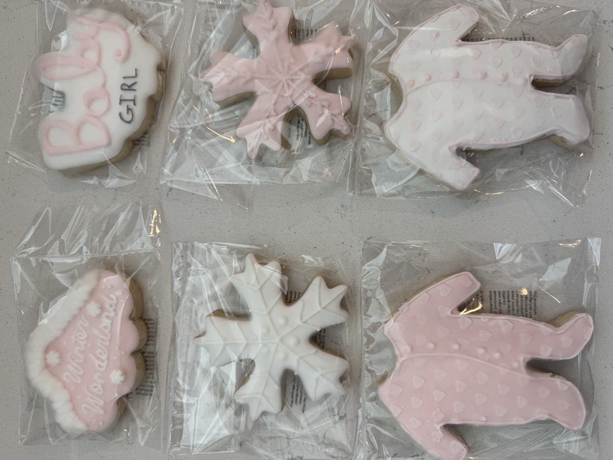 Individually wrapped pink baby girl decorated sugar cookies including a "Baby Girl" cookie, snowflakes, and footed pajama rompers