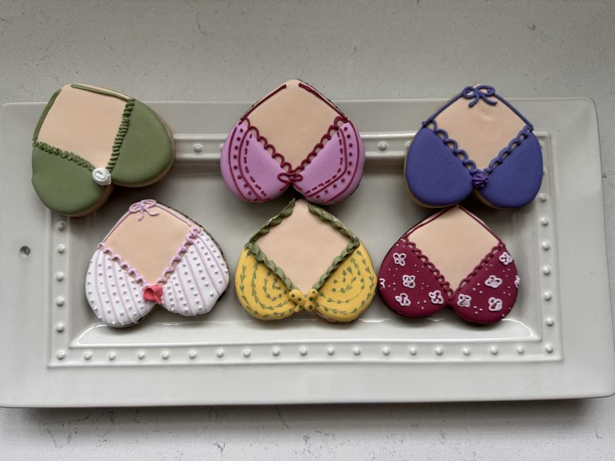 Heart-shaped decorated sugar cookies with bandana and gingham fabric patterns in red, yellow, white, purple, pink, and green