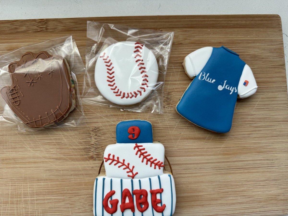 Baseball-themed decorated sugar cookies: a personalized jersey, a baseball, a chocolate mitt, and a team jersey