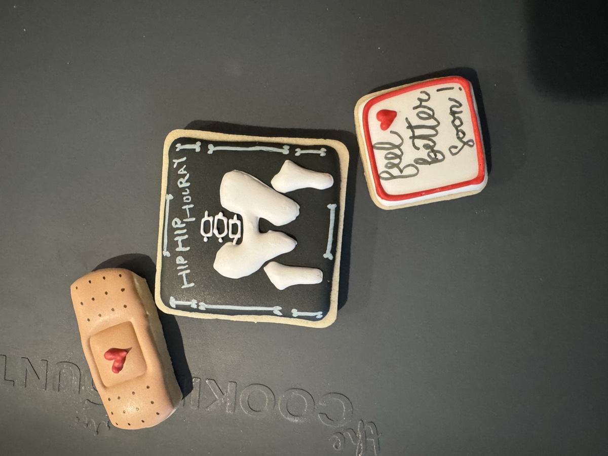 A bandage, a tooth cookie reading "Hip Hip Hooray", and a "Feel Better Soon!" decorated sugar cookie