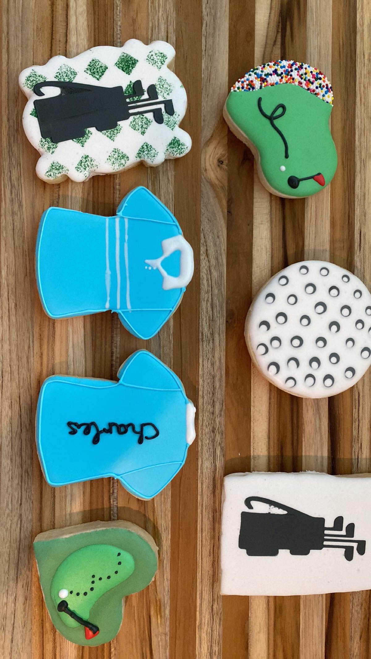 Golf themed decorated sugar cookies: a golf bag, a Grinch-golfer mashup, a personalized polo shirt, a golf ball, and a putting green