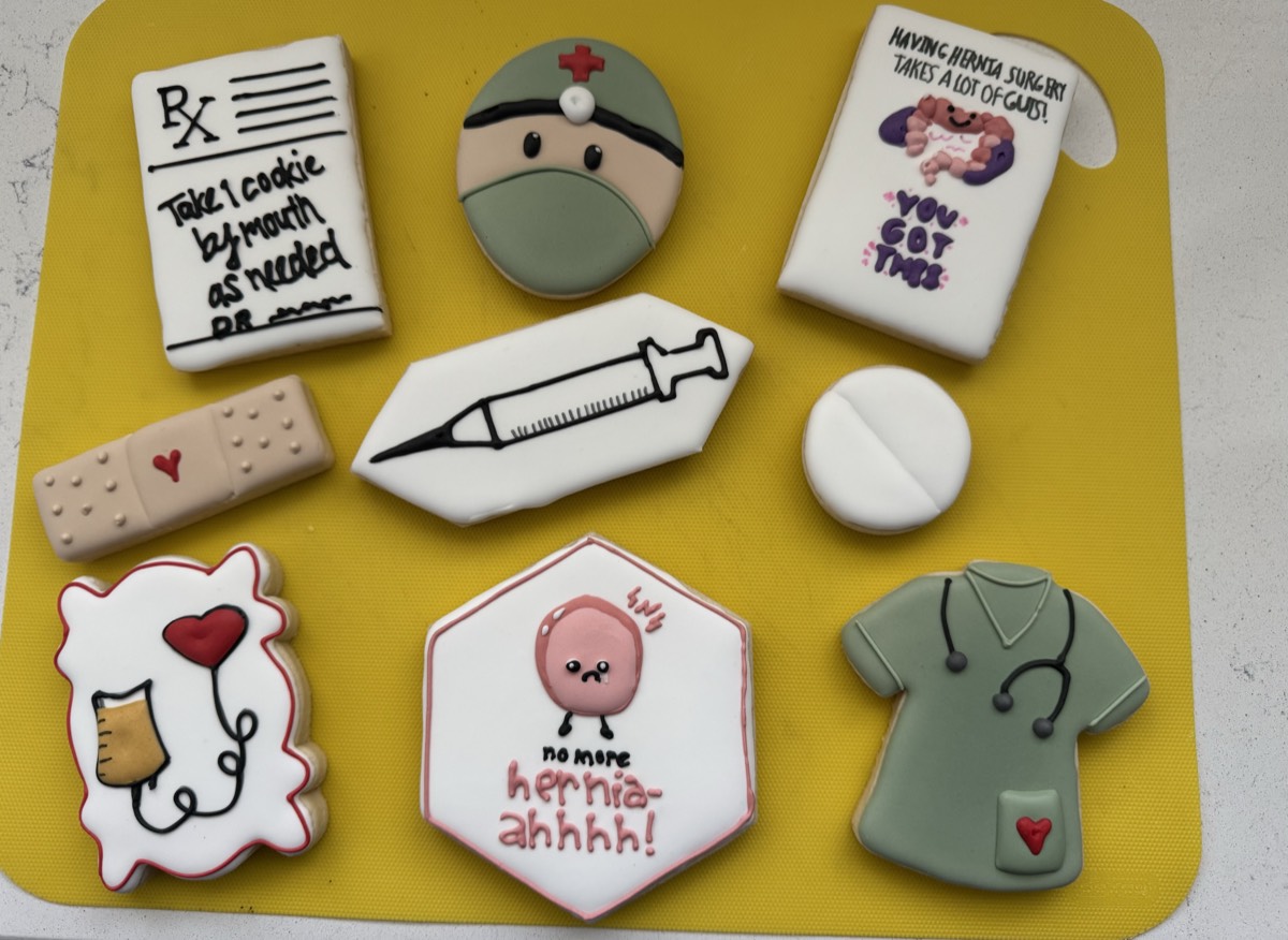 A medical humor decorated sugar cookie set: a prescription pad, a nurse cap, a bandage, a syringe, a pill, an IV heart, a scrub top, and a "no more hernia-ahhhh!" cookie